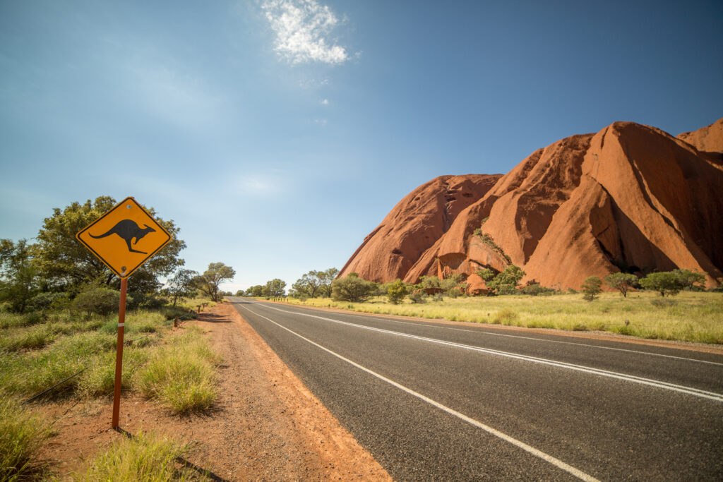 Der Highway mit einem Känguru-Warnschild im Outback in Australien