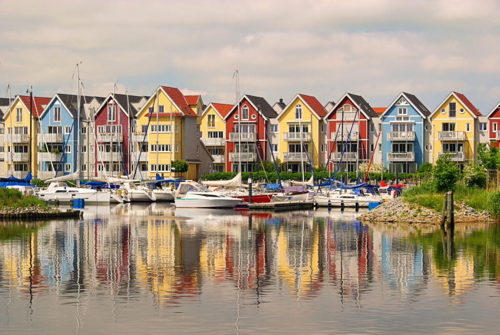 Bunte Ferienhäuser in Greifswald direkt am Wasser mit einigen Booten