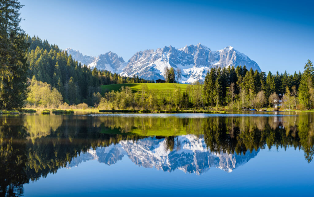 Idyllischer Alpenkulisse spiegelt sich in einem kleinen See in Kitzbühel in Tirol
