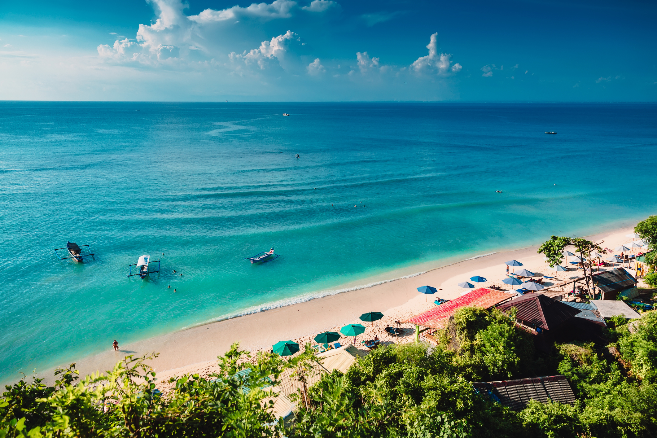 Tropischer Strand mit Booten und blauem Ozean auf Bali