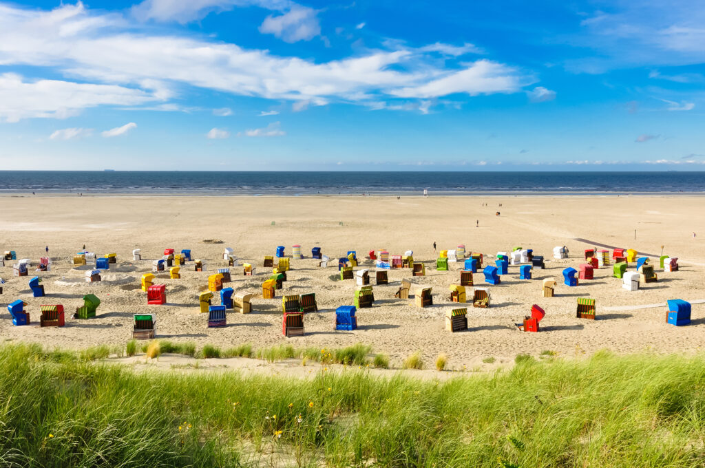 Viele bunte Strandkörbe am breiten Strand von der Insel Juist