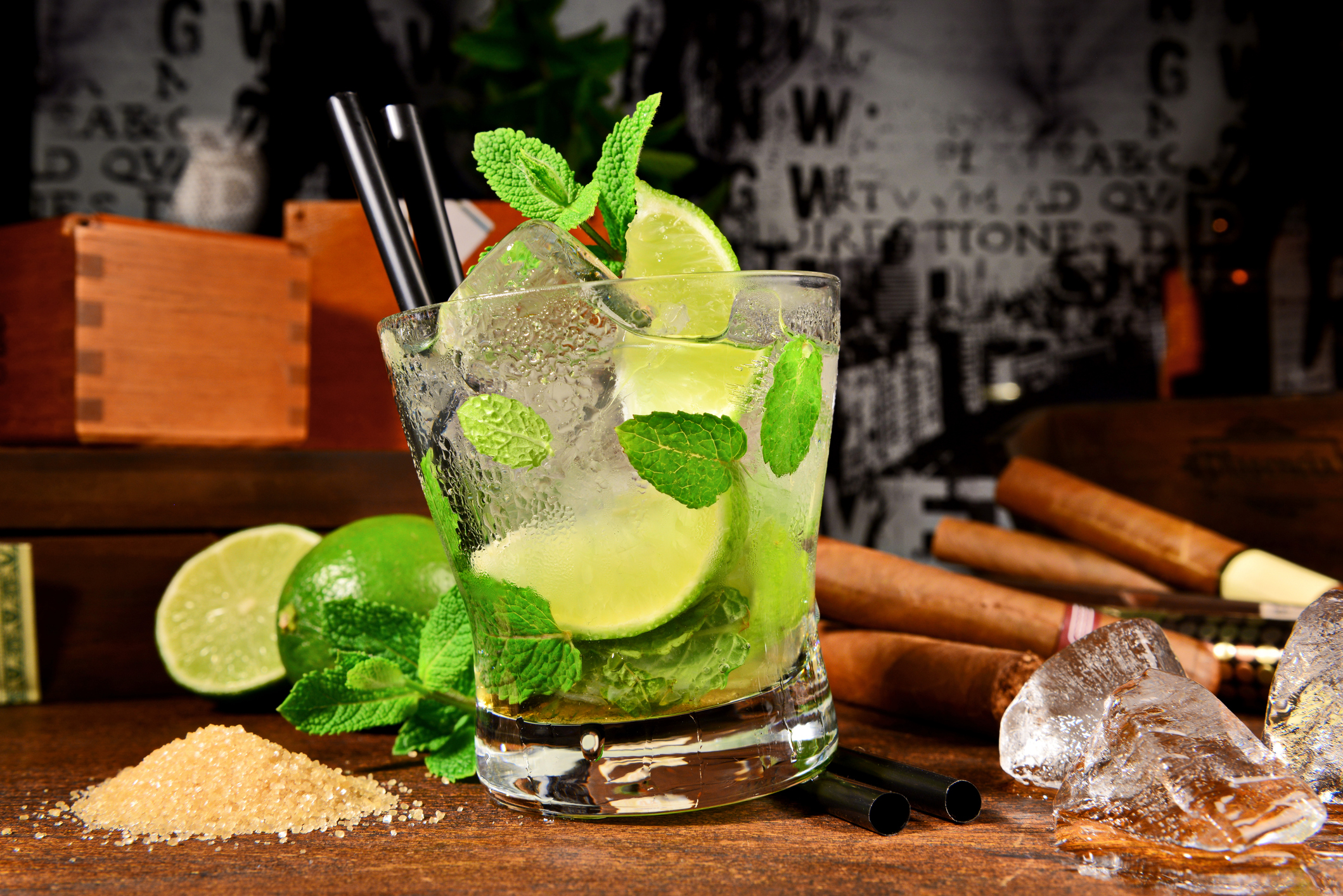 Ein leckerer Mojito und im Hintergrund ein Paar Zigarren