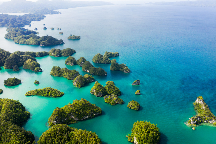 Grüne, tropische Inseln in Indonesien aus der Vogelperspektive, umgeben von türkisfarbenem Wasser.