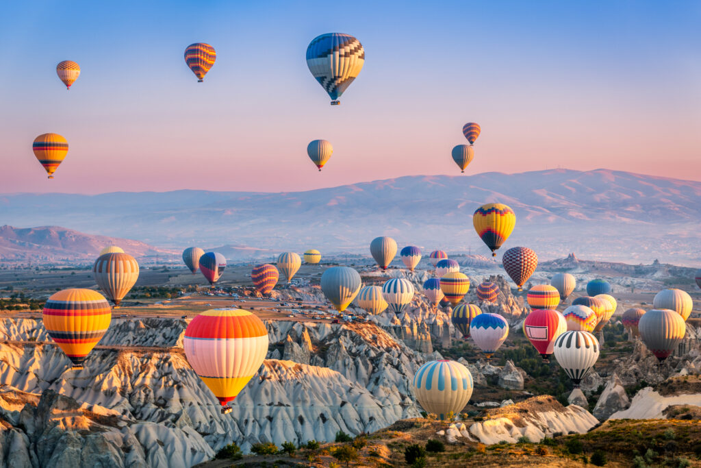 Luftaufnahme einer Flotte von Heißluftballons in Kappadokien, Türkei - Bildnachweis: Ultima_Gaina Stock-Datei-ID: 1484200613 – Lizenz vom: 03.07.2025
