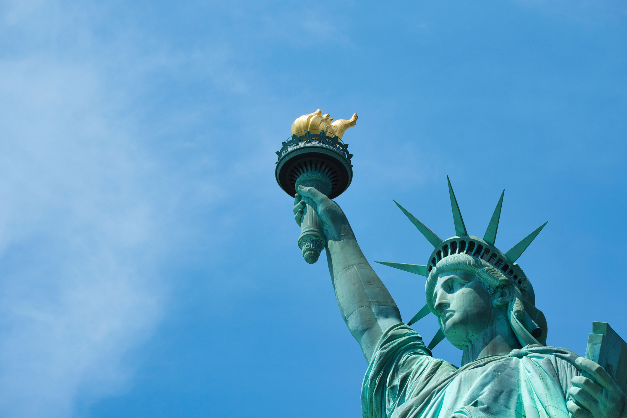 Kopf der Freiheitsstatue vor blauem Himmel, Nahaufnahme der ikonischen Krone.