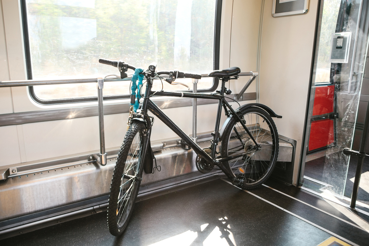 Schwarzes Fahrrad steht gesichert im Fahrradabteil eines modernen Zuges.