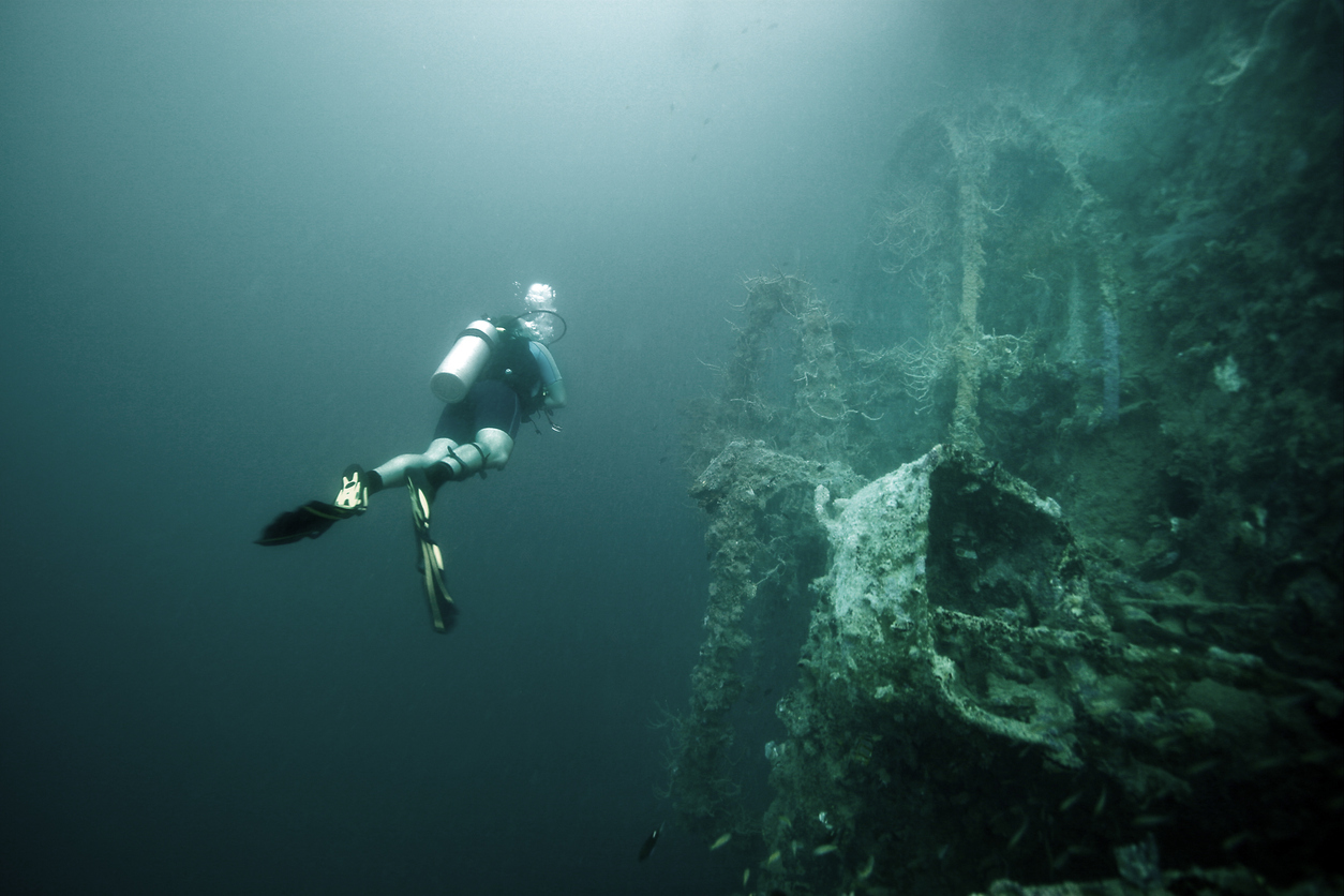 Taucher erkundet ein versunkenes Schiffswrack in den tiefen Gewässern der Philippinen.