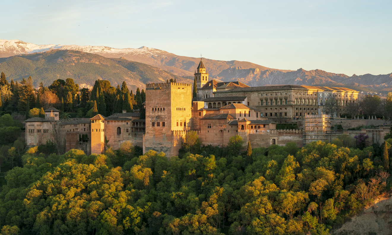 Die Alhambra in Granada, Spanien, vor der Kulisse der schneebedeckten Sierra Nevada bei Sonnenuntergang.