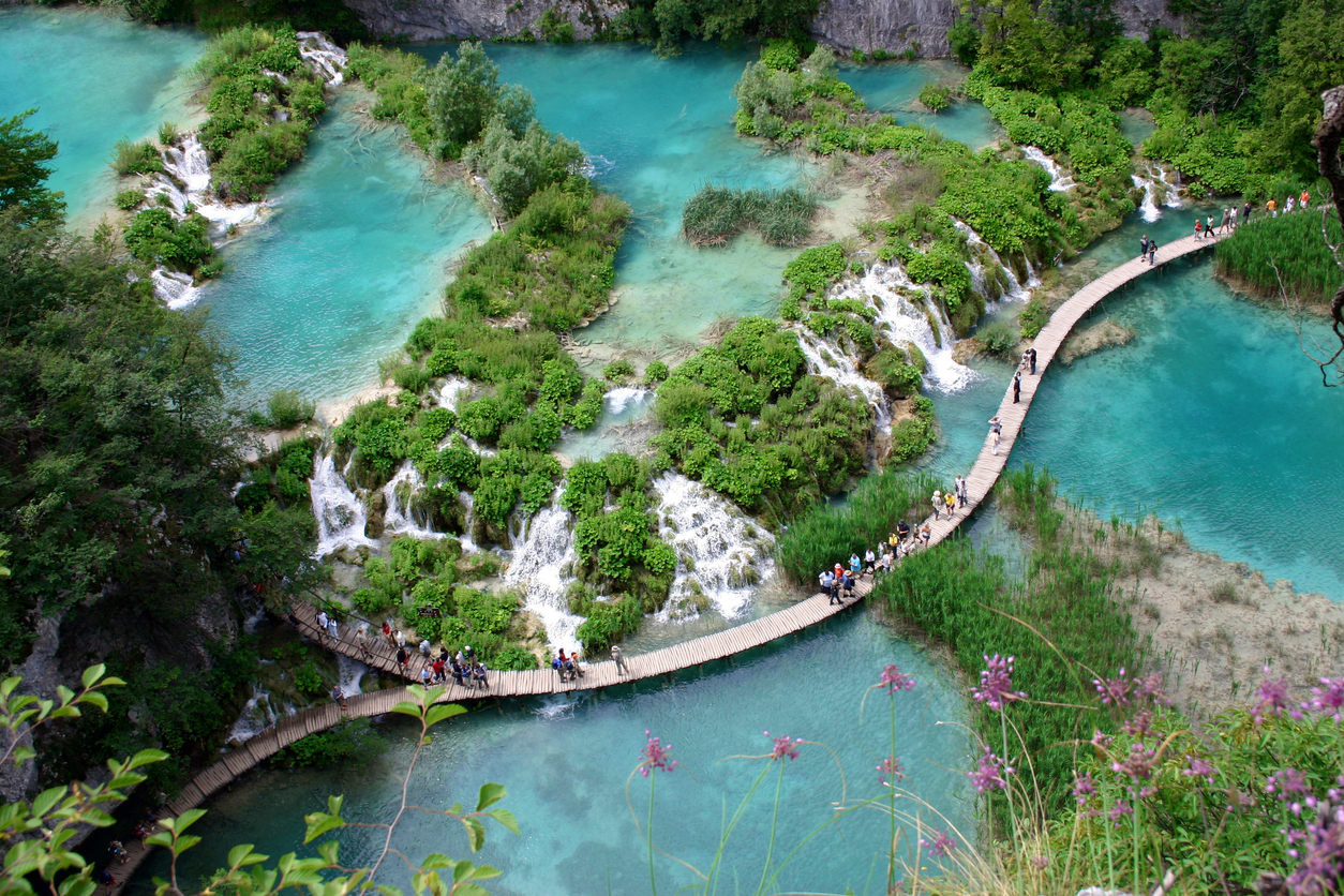 Holzstege führen Besucher durch die türkisfarbenen Seen und Kaskaden des Nationalparks Plitvicer Seen in Kroatien.