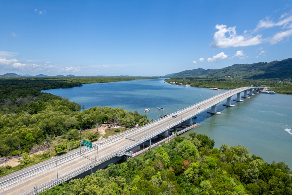 Luftaufnahme der Verbindungsbrücke zwischen Koh Lanta und Krabi in Thailand mit Blick auf Meer, Boote und grüne Landschaft.