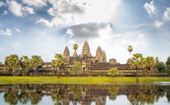 Die beeindruckende Tempelanlage Angkor Wat in Kambodscha, vor einem ruhigen See mit Spiegelung der Türme im Wasser.