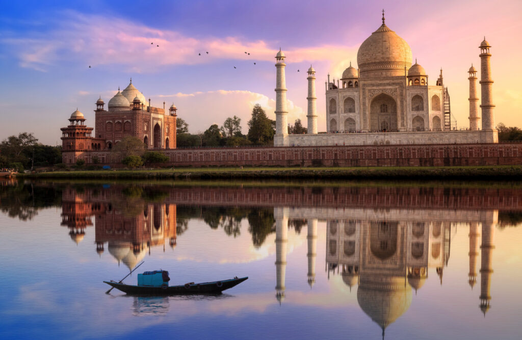 Das Taj Mahal in Agra, Indien, spiegelt sich im Wasser des Yamuna-Flusses bei Sonnenaufgang.