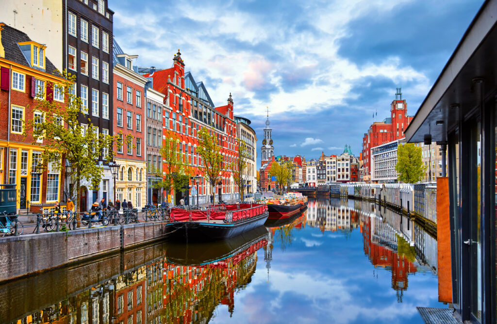Amsterdam-Gracht mit bunten Häusern, Booten und Spiegelung