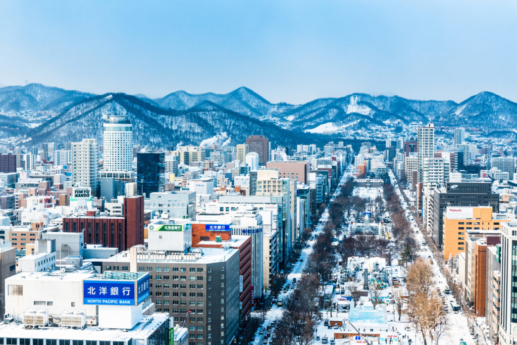 Sapporo im Winter mit Odori-Park, Schneeskulpturen und Bergen im Hintergrund