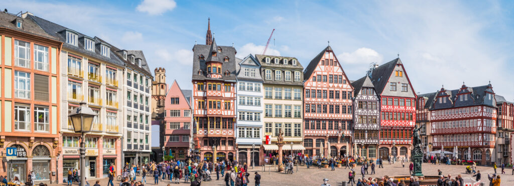 Historische Fachwerkhäuser am Römerberg in Frankfurt am Main mit vielen Menschen auf dem Platz.