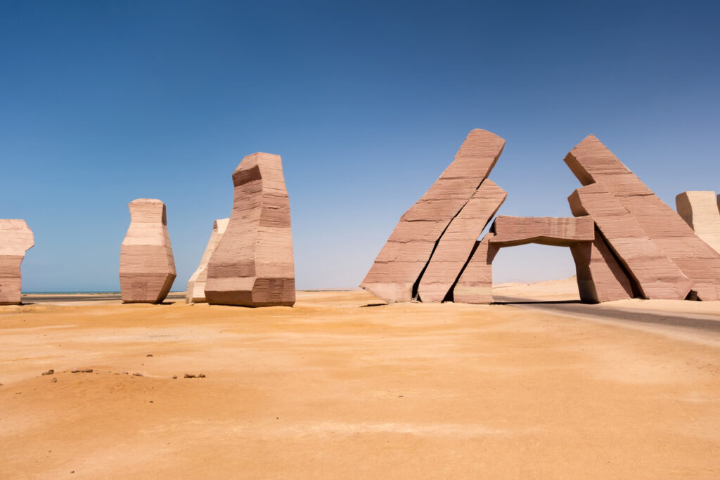 Monumentale Steinskulpturen am Eingang des Ras-Mohammed-Nationalparks in der Wüste, unter klarem, blauem Himmel.