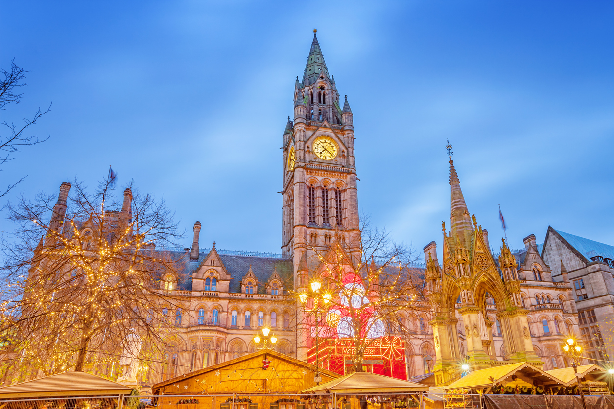 Weihnachtsmarkt in Manchester vor dem Rathaus am Albert Square bei Abenddämmerung