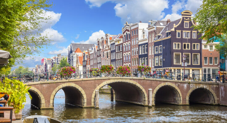 Amsterdam-Gracht mit Brücke, Fahrrädern und Giebelhäusern