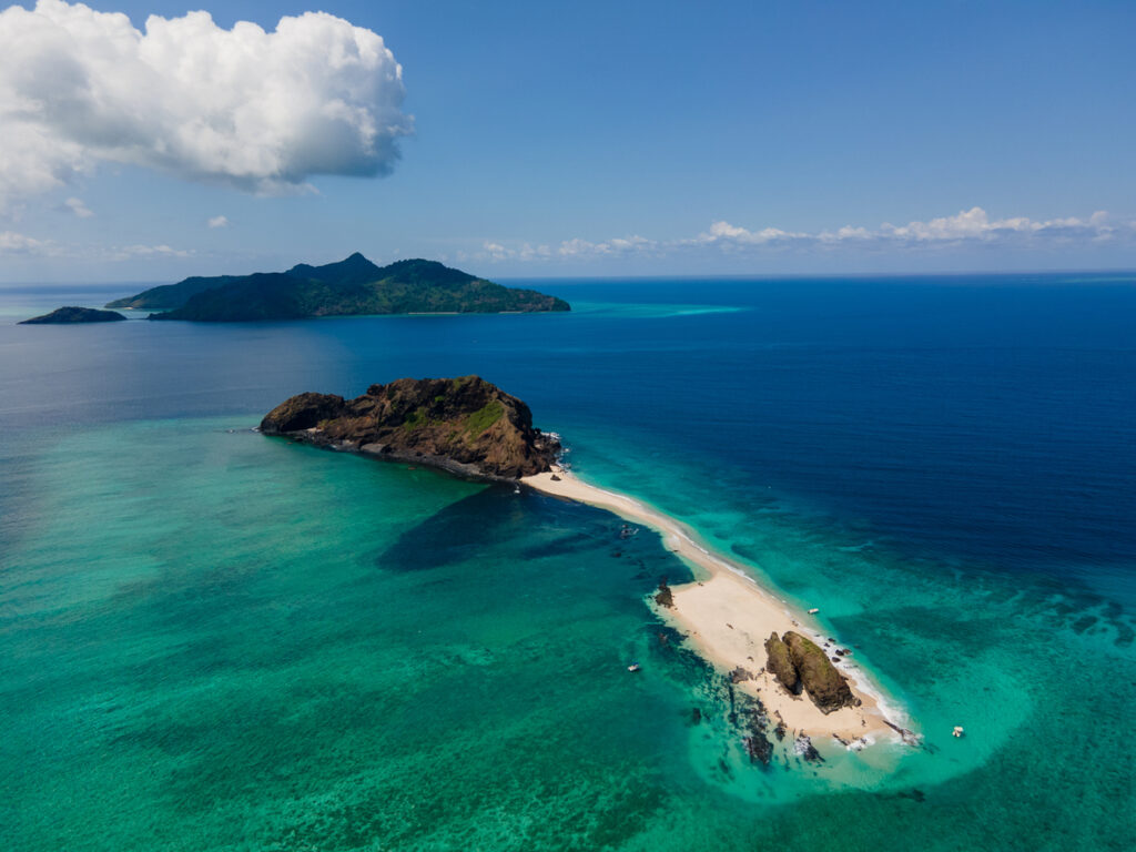 Aerial: schmale Sandbank zwischen Felseninseln in türkisblauer Lagune auf den Komoren.