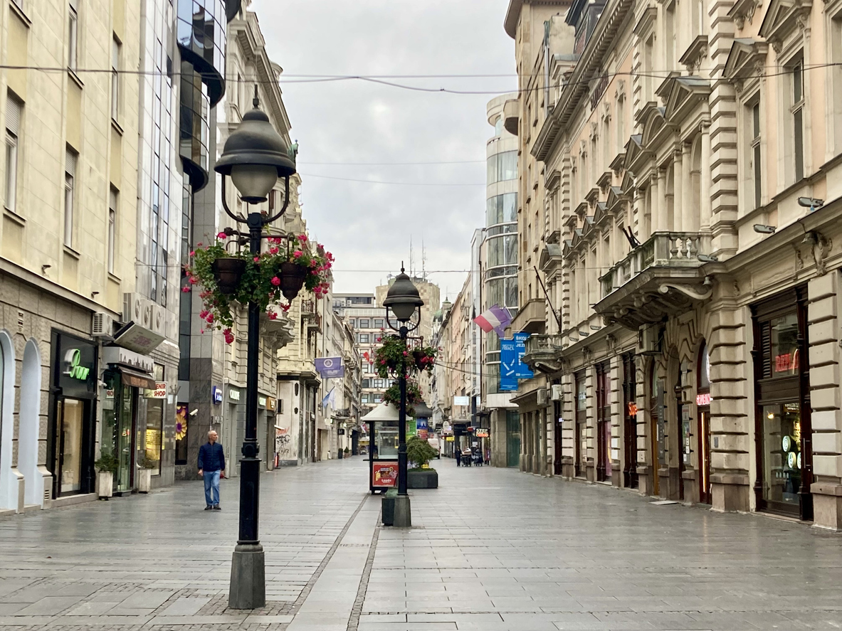 Belgrad, Knez-Mihailova-Straße als Fußgängerzone, historische Fassaden mit Balkonen, Geschäfte, schmiedeeiserne Laternen mit Blumenampeln, graues Pflaster, bedeckter Himmel