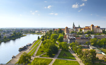 Panorama von Krakau mit der Weichsel, Spazierwegen und dem historischen Wawel-Schloss bei sonnigem Wetter.