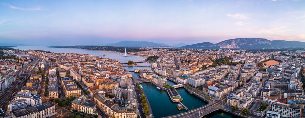 Panorama von Genf mit Jet d’Eau, Rhône und See bei Dämmerung