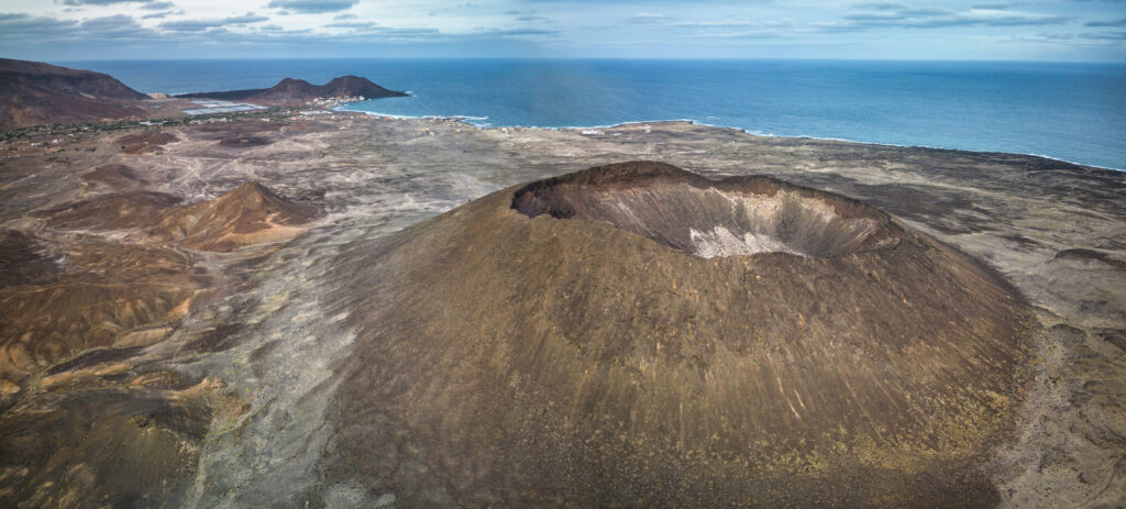 Luftaufnahme eines Vulkans mit großem Krater auf den Kapverden, im Hintergrund der Atlantik.