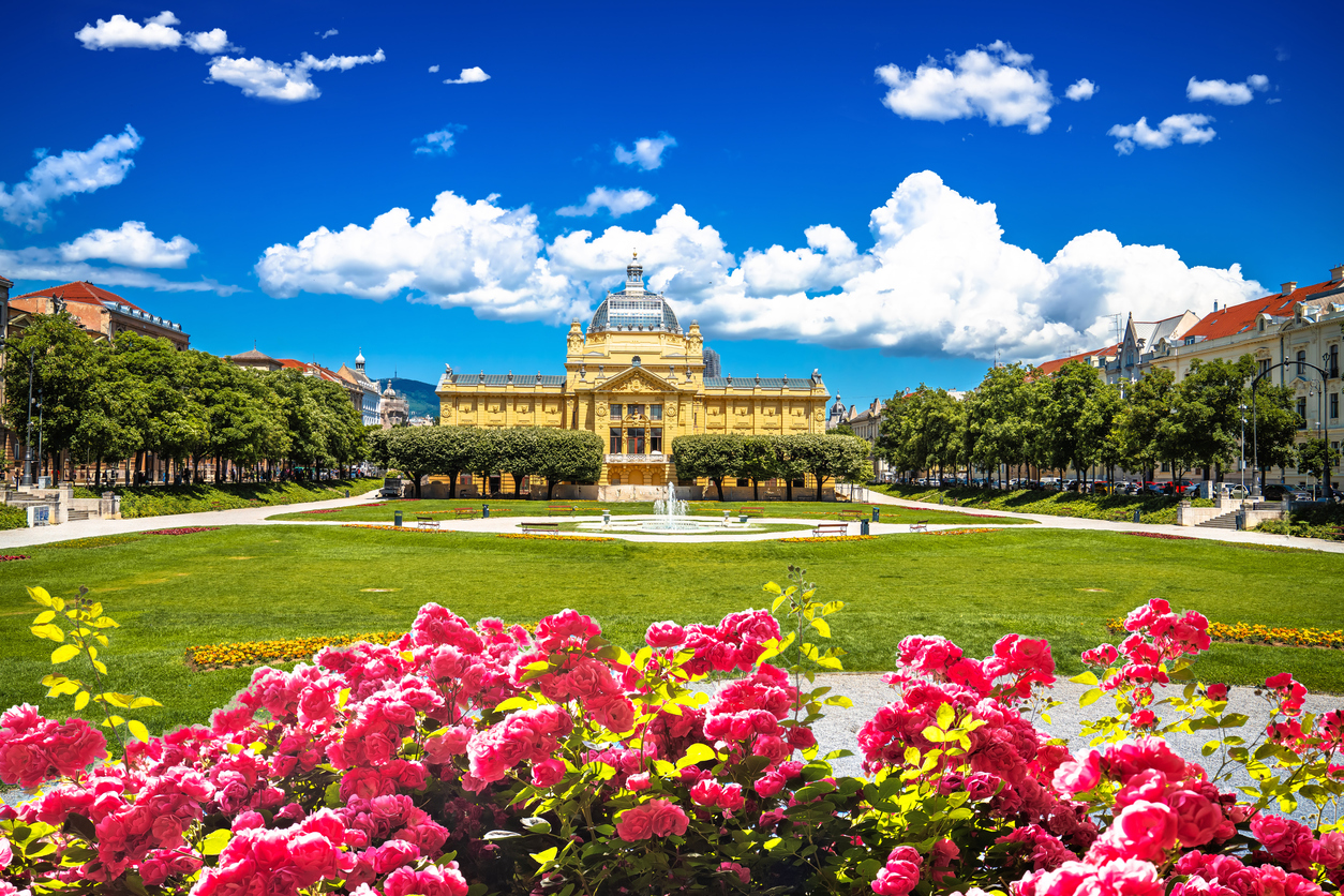 Ansicht des Kunstpavillons in Zagreb im König-Tomislav-Park mit bunten Blumen im Vordergrund.