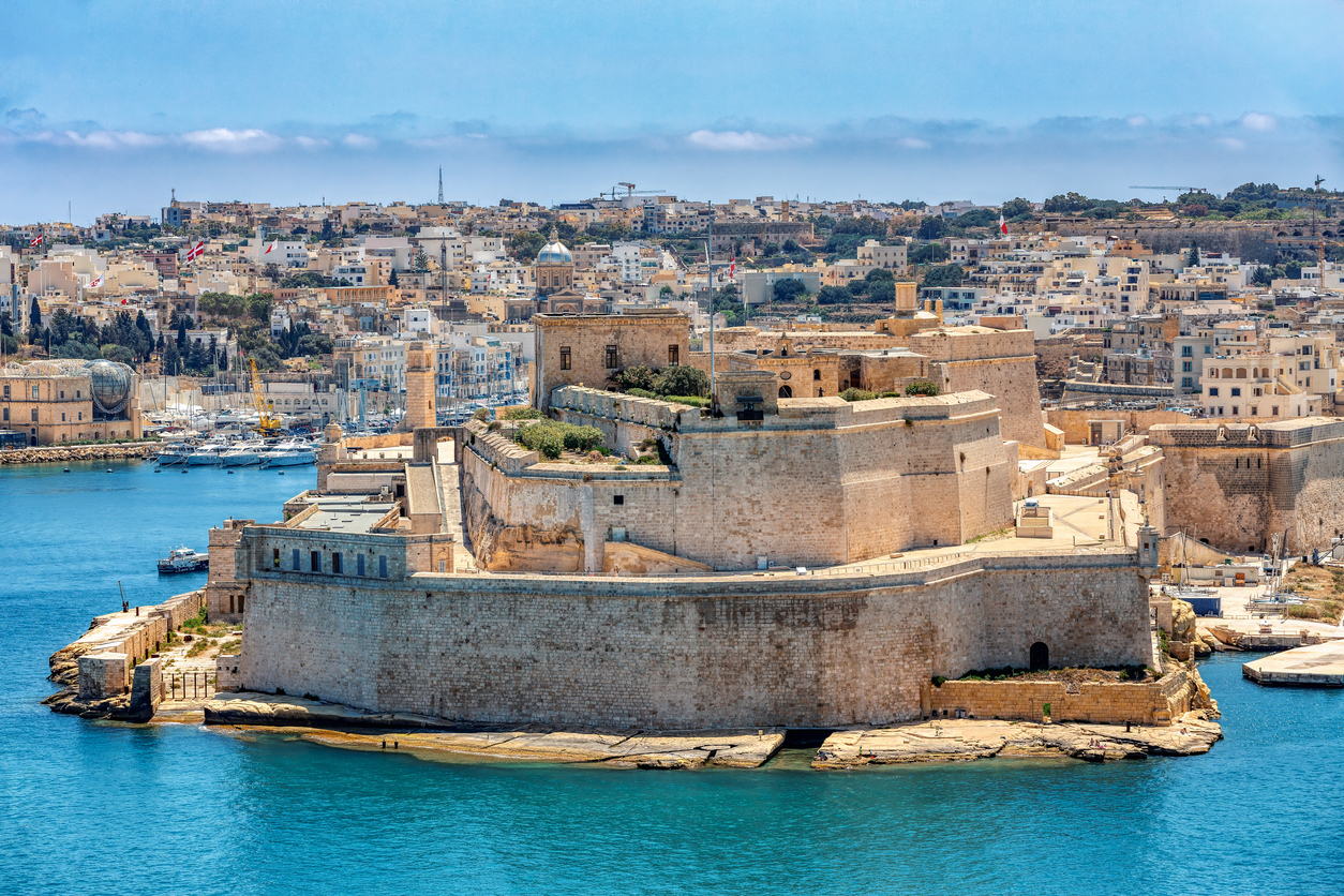 Blick auf das historische Fort St. Angelo im Hafen von Valletta, Malta, mit der Stadt im Hintergrund.
