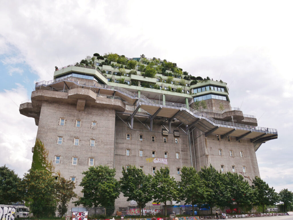 Hamburg, Hochbunker auf dem Heiligengeistfeld mit aufgesetzten grünen Terrassen und großen Glasfronten, massiver Betonkörper, frontal aufgenommen unter bedecktem Himmel