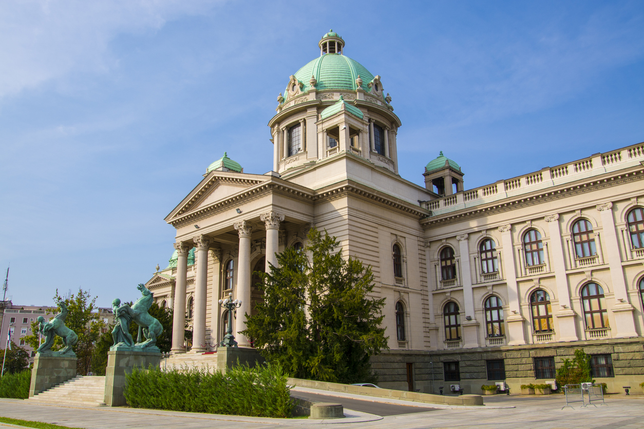 Belgrad, Parlamentsgebäude mit großer grüner Hauptkuppel und seitlichen Laternenkuppeln, klassizistischer Portikus mit Säulen, bronzene Pferdeskulpturen, klarer Himmel