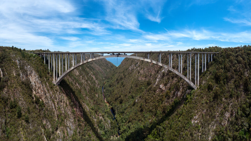 Weite Ansicht der Bloukrans-Brücke über der grünen Schlucht im Tsitsikamma mit Bungee-Seil und Fluss.