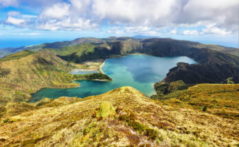 Panoramablick auf die Lagoa do Fogo, einen türkisfarbenen Kratersee auf São Miguel, umgeben von grünen Vulkanhängen und Wolken