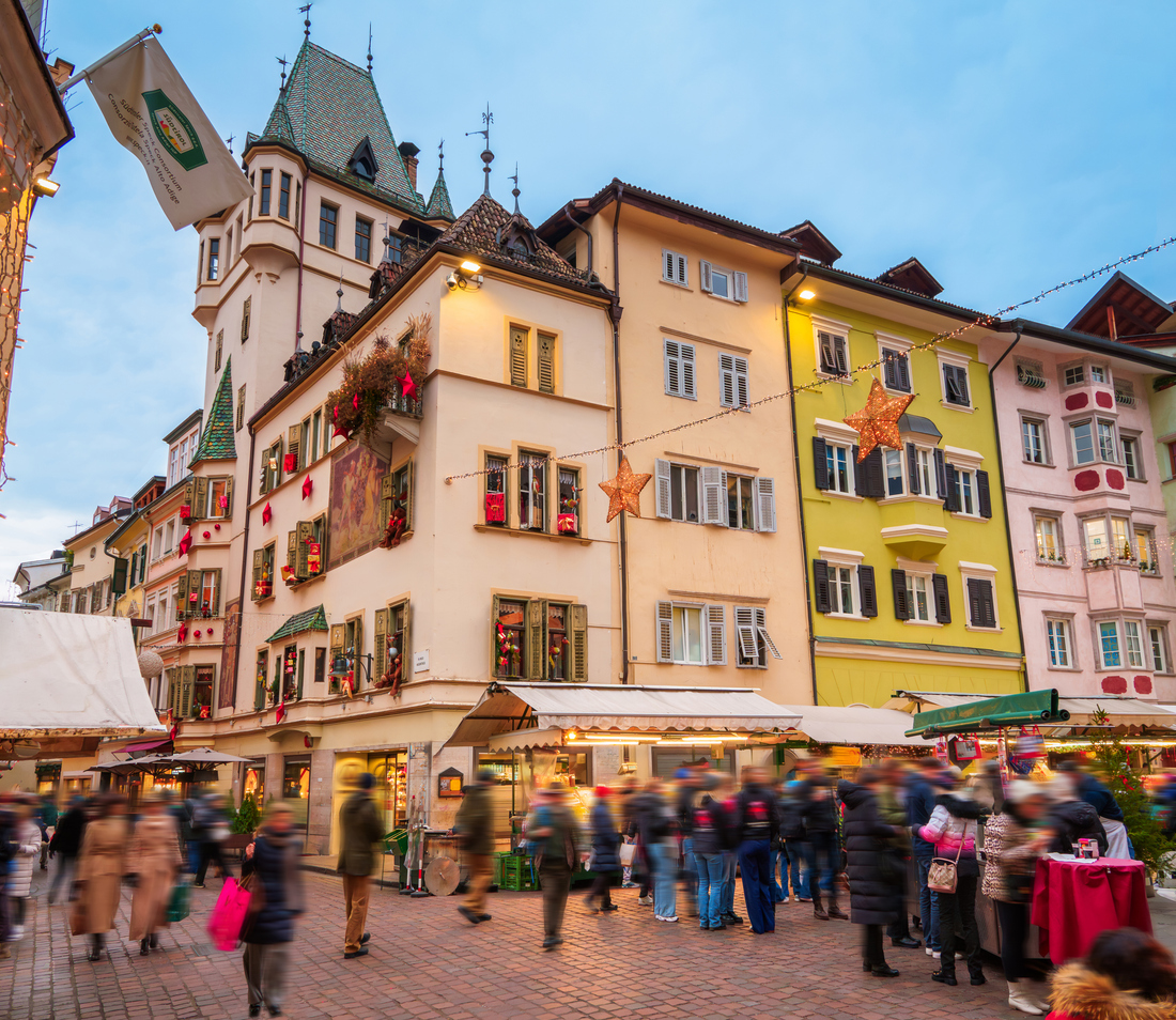 Bozner Weihnachtsmarkt mit geschmückten Häusern und Marktständen