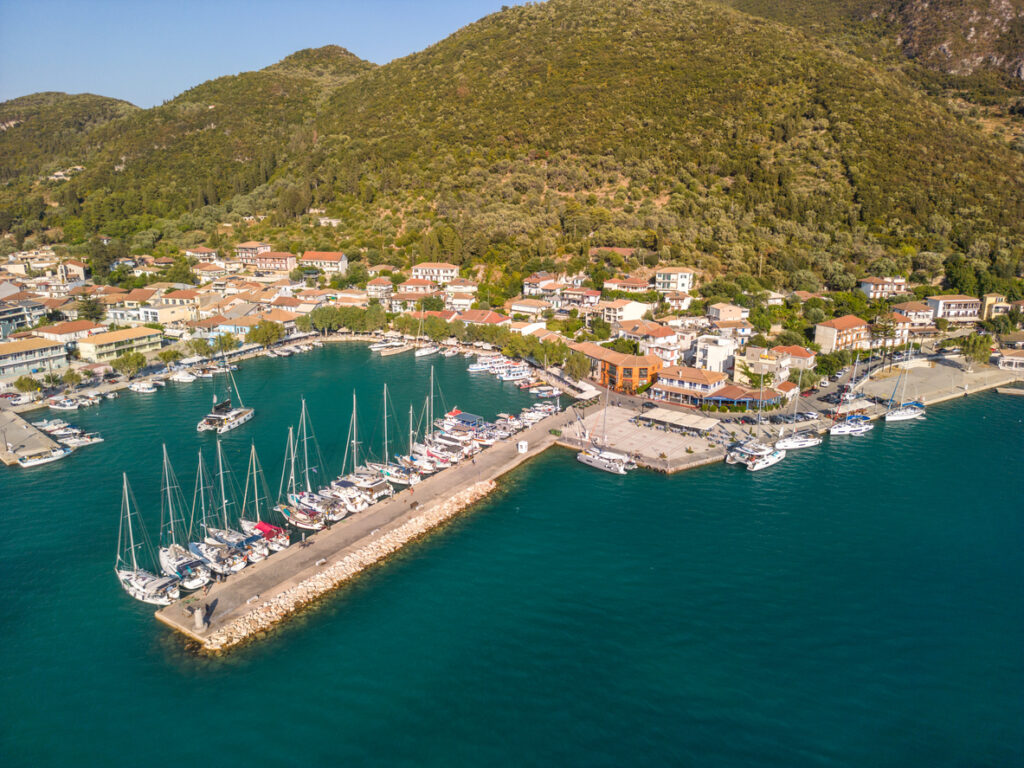 Marina auf Lefkada mit Segelbooten, Piers, Häusern und grünen Hügeln, Luftaufnahme.