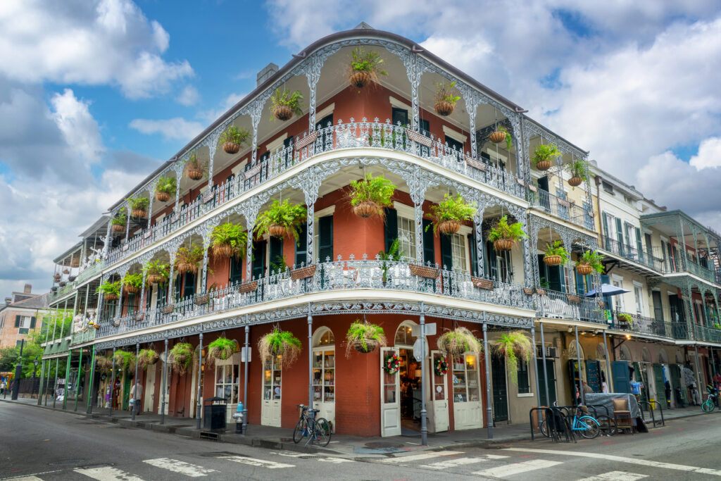 Eckhaus aus Backstein mit umlaufenden schmiedeeisernen Galerien und Hängepflanzen im French Quarter.