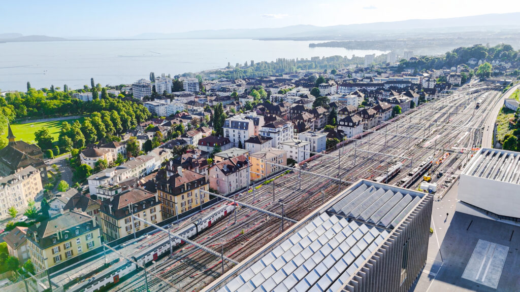 Lausanne mit Bahnhofsgleisen und Genfersee im Hintergrund