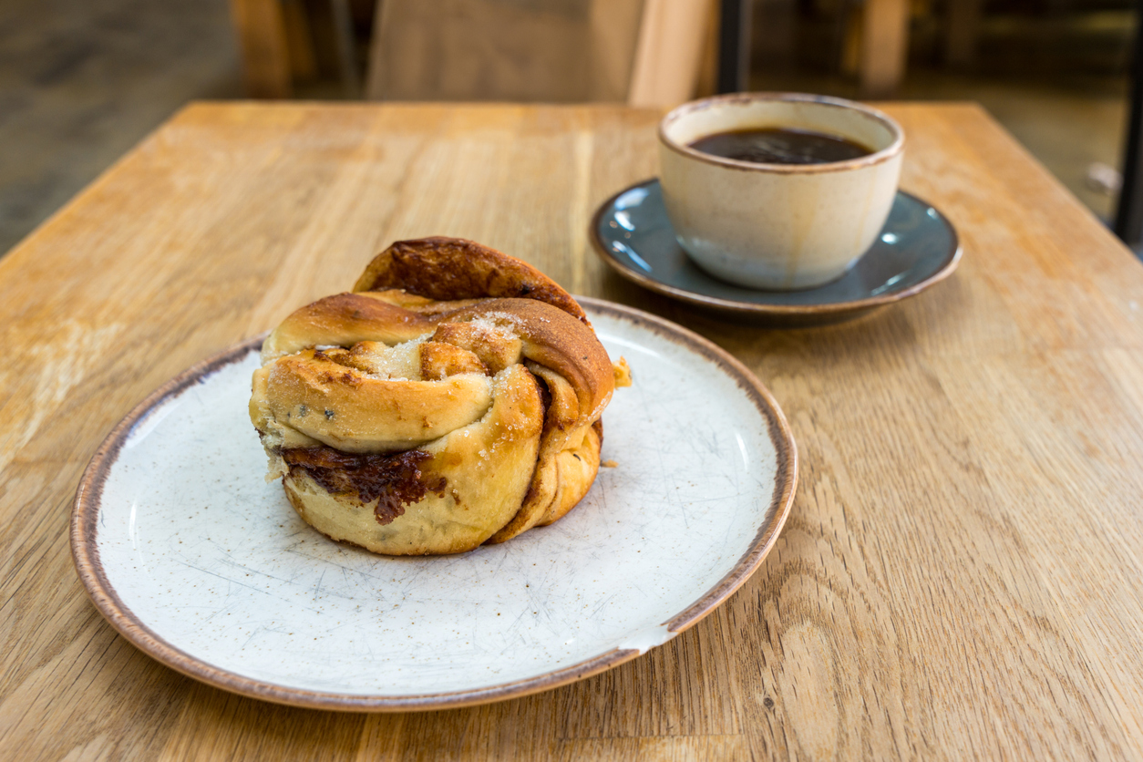 Frische Zimtschnecke mit einer Tasse Kaffee in einem Café in Oslo.