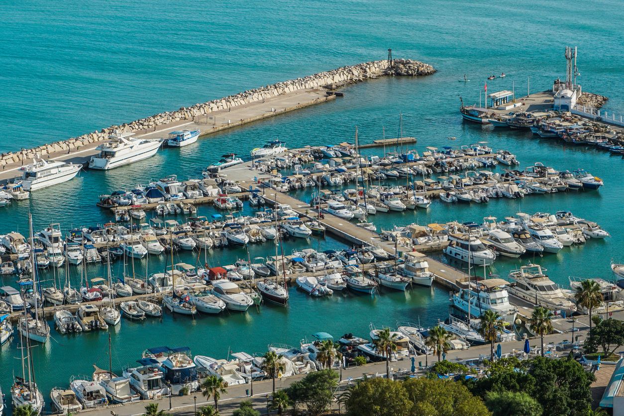 Blick auf den Yachthafen von Sidi Bou Said mit zahlreichen Booten, Mole und türkisfarbenem Meer.