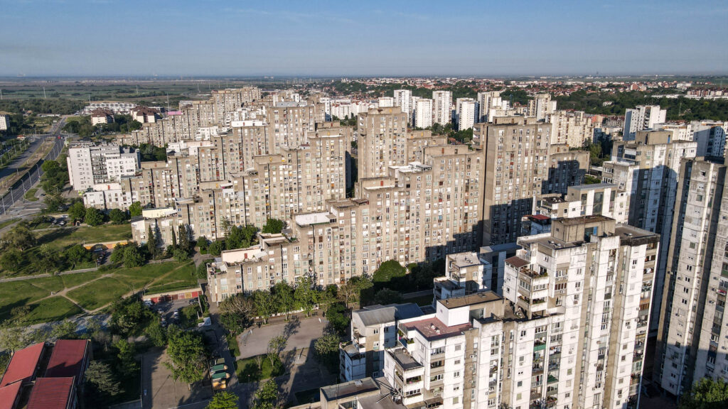 Belgrad, dichte Reihen hoher Beton-Wohnblocks mit Balkonen in Novi Beograd, dazwischen Grünflächen und Straßen, Blick von oben bei klarem Himmel