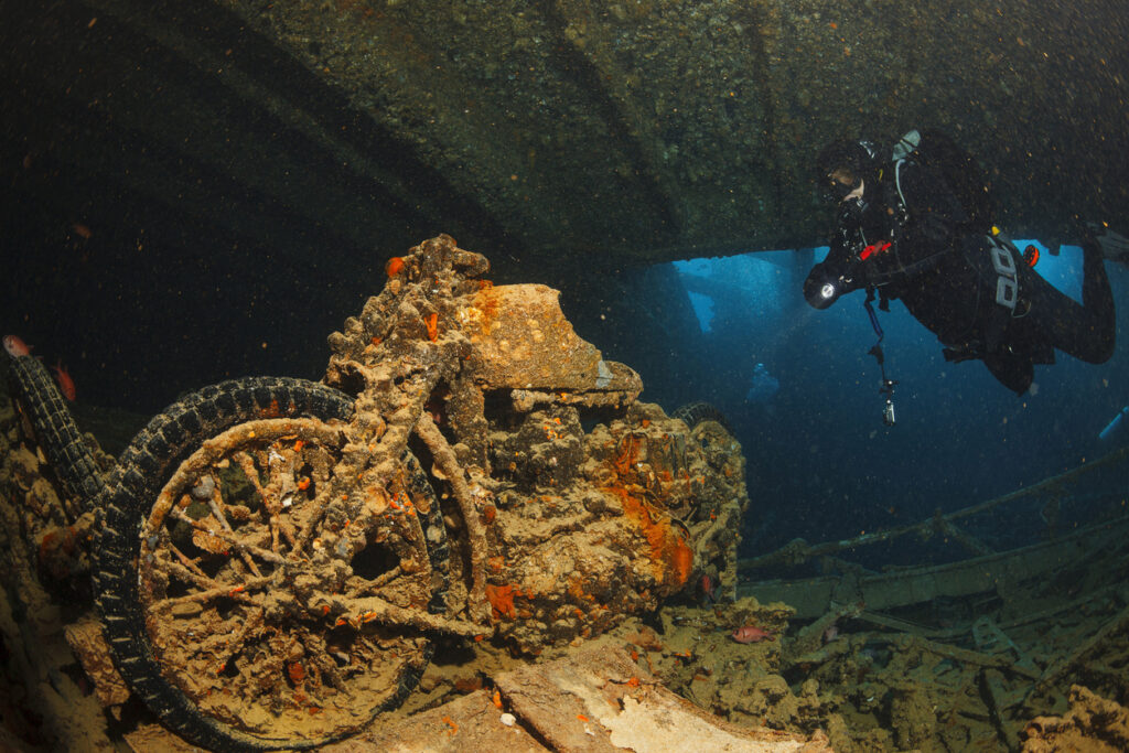 Taucher untersucht ein Motorrad im Wrack der SS Thistlegorm im Roten Meer.