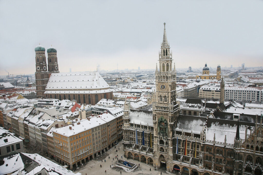 Panoramablick auf den Marienplatz in München mit Frauenkirche und Rathaus im Schnee.