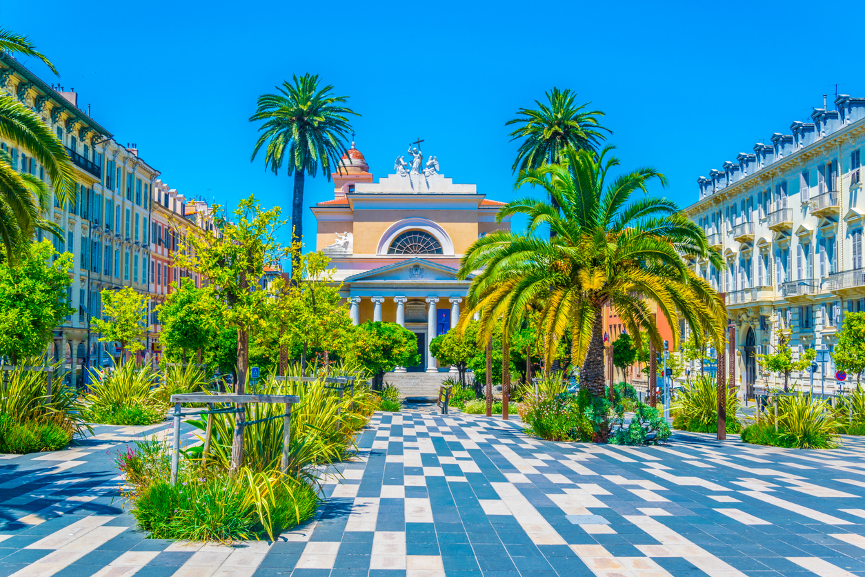 Palmengesäumte Promenade führt zur Kirche Saint-Jean-Baptiste in Nizza.
