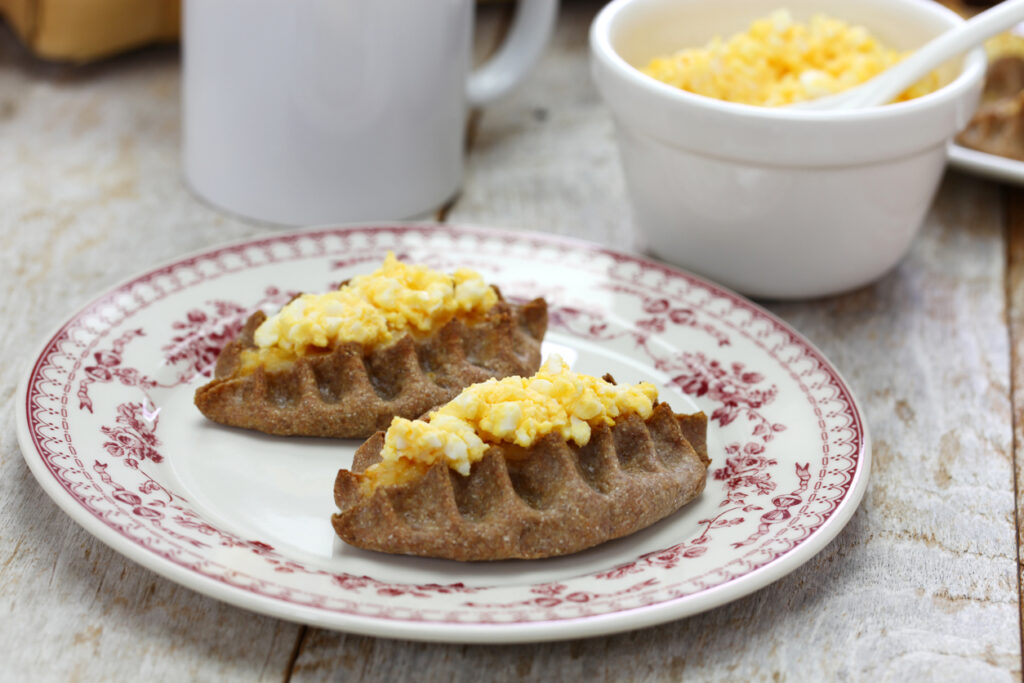 Karelische Piroggen mit Eierbutter auf einem Teller, finnische Spezialität.