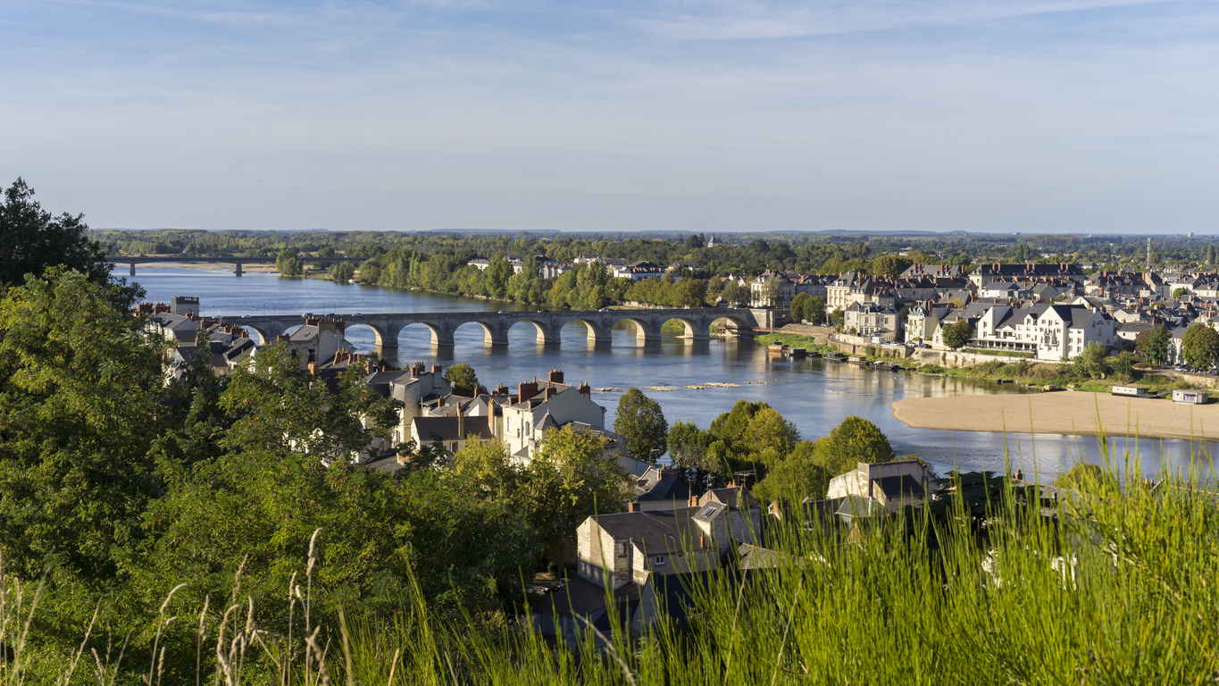 Panorama von Saumur an der Loire mit historischer Steinbogenbrücke und Sandbank.