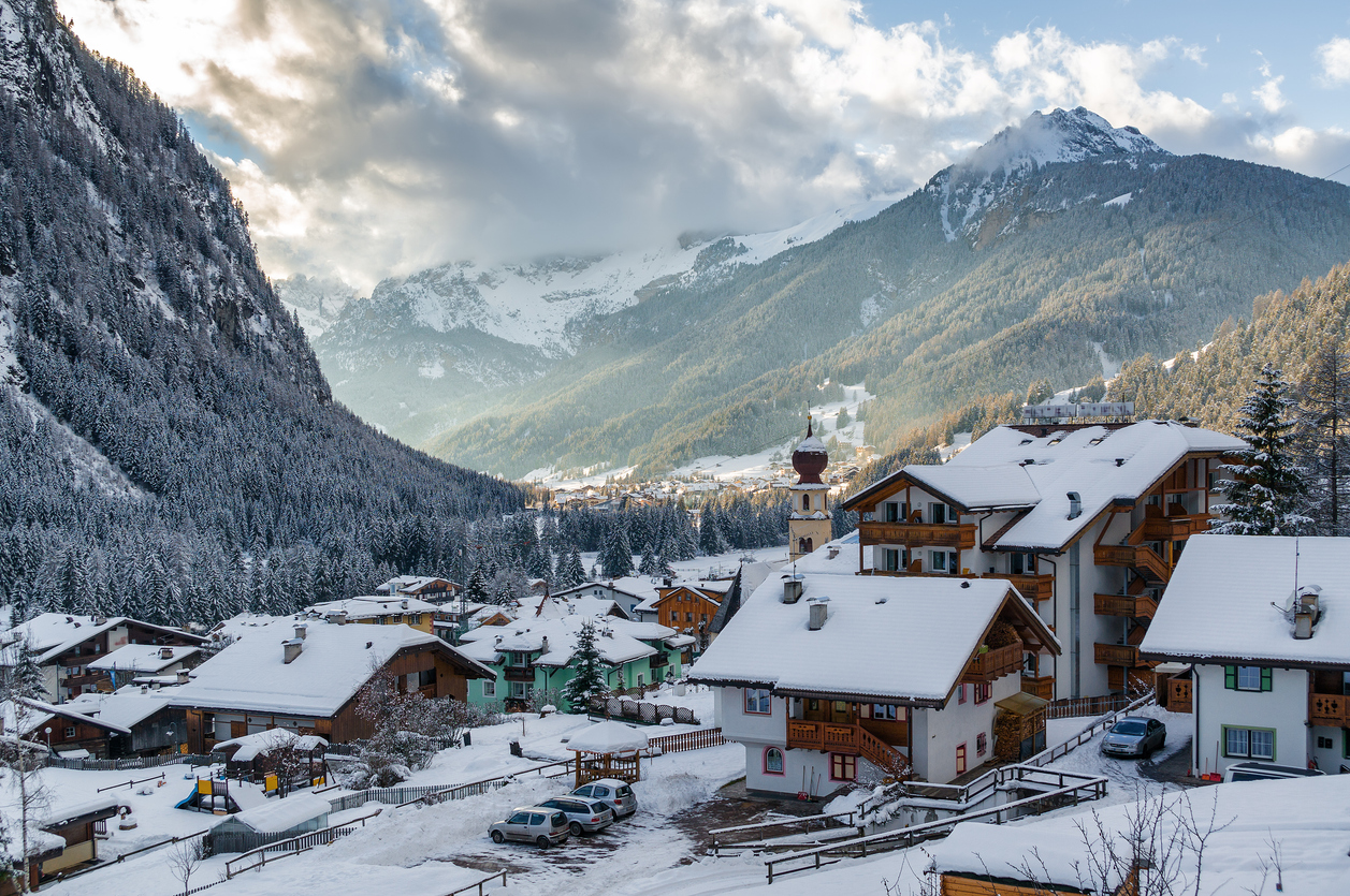 Verschneites Canazei mit Zwiebelturm und Chalets im Val di Fassa.