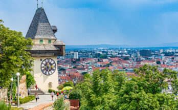 Der Uhrturm blickt vom Schlossberg über die Dächer von Graz.