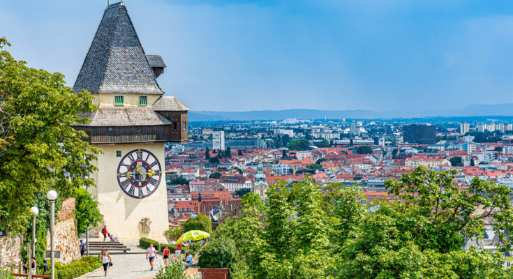 Der Uhrturm blickt vom Schlossberg über die Dächer von Graz.
