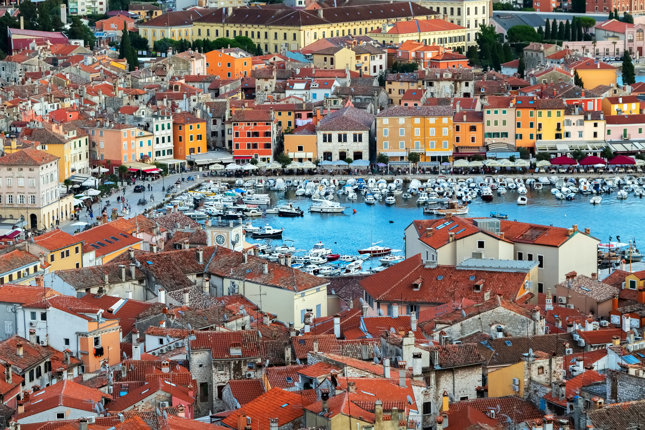 Blick auf Hafenbecken mit Booten und farbigen Häuserreihen an der Promenade.