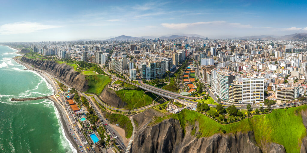 Panoramablick auf Miraflores mit grünen Klippen, Küstenstraße und Hochhäusern am Pazifik.